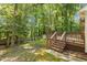 Large fenced backyard with a wooden deck, mature trees, and a storage shed at 6129 Krandon Dr, Raleigh, NC 27603