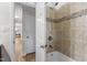 Bathroom shower-tub combo features decorative tile, with access to the hallway and wood laminate flooring at 6129 Krandon Dr, Raleigh, NC 27603