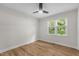 This bedroom features beautiful laminate flooring, white walls, ceiling fan and a large window at 6129 Krandon Dr, Raleigh, NC 27603