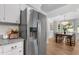 Kitchen view with stainless fridge, granite counters, and view into dining room with seating at 6129 Krandon Dr, Raleigh, NC 27603