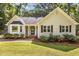 Charming home featuring manicured lawn, mature landscaping, and inviting front porch at 6129 Krandon Dr, Raleigh, NC 27603