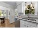 Bright kitchen view with granite counters, stainless dishwasher, and view into adjacent dining room at 6129 Krandon Dr, Raleigh, NC 27603