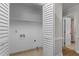 White laundry room featuring tile floors, folding doors, and a closet shelf at 6129 Krandon Dr, Raleigh, NC 27603