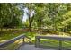 View of spacious back yard from the deck with lush vegetation at 6817 Guess Rd, Hillsborough, NC 27278