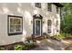 Charming home entrance featuring a beautifully adorned front door with tasteful landscaping and elegant lighting fixtures at 6817 Guess Rd, Hillsborough, NC 27278