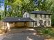 Traditional white brick home featuring a convenient carport and well-manicured front yard, surrounded by mature trees at 6817 Guess Rd, Hillsborough, NC 27278