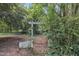 A lush backyard features a trellis entrance, surrounded by dense trees, adding a magical touch at 705 Wilsons Mills Rd, Smithfield, NC 27577