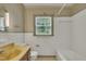Bathroom with tiled walls, shower/tub combo, vanity, and large window at 705 Wilsons Mills Rd, Smithfield, NC 27577