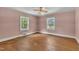 Bedroom with hardwood floors, two windows, and ceiling fan at 705 Wilsons Mills Rd, Smithfield, NC 27577