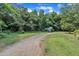 A winding gravel driveway leads to a quaint white outbuilding, adding to the property's allure at 705 Wilsons Mills Rd, Smithfield, NC 27577