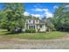 A beautiful two-story home with a well-maintained lawn and garden area, surrounded by lush green trees at 705 Wilsons Mills Rd, Smithfield, NC 27577