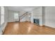 Living room featuring a classic fireplace, hardwood floors, and a staircase to the upper level at 705 Wilsons Mills Rd, Smithfield, NC 27577