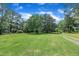 Lush green yard with mature trees and beautiful landscaping surrounds this charming home at 705 Wilsons Mills Rd, Smithfield, NC 27577