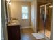 Bright bathroom featuring a double vanity with granite countertops and a glass-enclosed shower with tile surround at 825 Fulworth Ave, Wake Forest, NC 27587