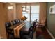 Dining room with dark wood table set for six, stylish light fixture, and large windows at 825 Fulworth Ave, Wake Forest, NC 27587