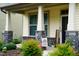 Inviting front porch with stone pillars and decorative plants and a welcome sign at 825 Fulworth Ave, Wake Forest, NC 27587