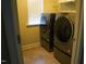 Modern laundry room with front-load washer and dryer, tile flooring, and window for natural light at 825 Fulworth Ave, Wake Forest, NC 27587