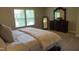 A spacious main bedroom featuring natural light, neutral tones, plush carpet, and a decorative dresser with mirror at 825 Fulworth Ave, Wake Forest, NC 27587