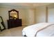 A spacious main bedroom featuring neutral tones, a plush carpet, and a decorative dresser with mirror at 825 Fulworth Ave, Wake Forest, NC 27587