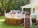 Expansive multi-level deck with hot tub, dining set, and elegant outdoor decor at 8909 Wellsley Way, Raleigh, NC 27613