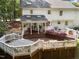Expansive tiered deck with hot tub, seating, and manicured flower beds, perfect for outdoor living at 8909 Wellsley Way, Raleigh, NC 27613