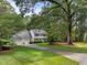 A beautiful two story home with a three car garage, long driveway, and manicured front lawn with mature trees at 8909 Wellsley Way, Raleigh, NC 27613