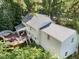 An exterior aerial view of a lovely home with a beautiful deck surrounded by lush greenery and mature trees at 8909 Wellsley Way, Raleigh, NC 27613