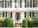 Charming front entrance with a black door and brick steps framed with shrubbery at 8909 Wellsley Way, Raleigh, NC 27613