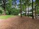 Beautiful front yard with lush lawn, mature trees, and view of a traditional style home with black shutters at 8909 Wellsley Way, Raleigh, NC 27613