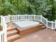 Outdoor hot tub on a wooden deck, surrounded by a white railing and lush trees at 8909 Wellsley Way, Raleigh, NC 27613