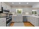 Bright kitchen featuring white cabinets, stainless steel appliances, and a window offering a view of the outdoors at 8909 Wellsley Way, Raleigh, NC 27613
