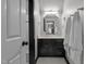 Elegant bathroom features a black vanity, marble countertop, and black and white tile flooring at 901 Tamaras Cir, Wake Forest, NC 27587