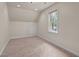 Upstairs bonus room featuring neutral paint and carpeting with natural light at 901 Tamaras Cir, Wake Forest, NC 27587