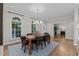 Hardwood dining room featuring a modern chandelier and elegant windows that flood the space with light at 901 Tamaras Cir, Wake Forest, NC 27587