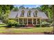 Charming brick home featuring symmetrical facade, dormer windows, and a covered front porch with seating at 901 Tamaras Cir, Wake Forest, NC 27587