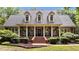 Charming brick home featuring a welcoming front porch with rocking chairs and manicured landscaping at 901 Tamaras Cir, Wake Forest, NC 27587
