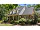 A delightful side view of a brick home showcases the inviting front porch and beautifully landscaped surroundings at 901 Tamaras Cir, Wake Forest, NC 27587