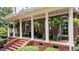 Inviting front porch with rocking chairs, ferns, and elegant columns creates a cozy outdoor space at 901 Tamaras Cir, Wake Forest, NC 27587
