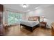 Calm main bedroom features hardwood floors, lots of natural light, and elegant furnishings at 901 Tamaras Cir, Wake Forest, NC 27587