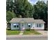 Cozy one-story home with light blue awnings, a brick chimney, and inviting front steps at 906 Camden Ave, Durham, NC 27701