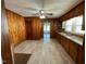 Bright kitchen with a ceiling fan, wood cabinets, and wood paneling at 906 Camden Ave, Durham, NC 27701