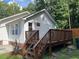 View of the home's rear exterior featuring a wooden deck, white siding, and a partially fenced-in backyard at 906 Camden Ave, Durham, NC 27701