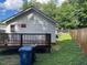View of the home's rear exterior featuring a wooden deck, white siding, and a partially fenced-in backyard at 906 Camden Ave, Durham, NC 27701