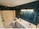 Modern bath with teal tile, a white double vanity, and a tub/shower combo at 922 Edgewater Cir, Chapel Hill, NC 27516