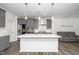 Kitchen with a large island, modern gray cabinets, stainless steel appliances, and luxury vinyl plank flooring at 937 Baldwin Ridge Rd, Apex, NC 27523