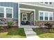 Inviting front porch with seating, landscaped garden, and a charming entryway at 937 Baldwin Ridge Rd, Apex, NC 27523