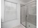 Bright tiled shower with a glass door, next to a window with closed blinds at 937 Baldwin Ridge Rd, Apex, NC 27523