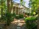 Serene backyard featuring a stone pathway leading to a screened-in porch, surrounded by mature trees at 1 Gatesway Ct, Durham, NC 27707