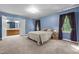 Spacious bedroom with plush carpet, blue walls, and a connected bathroom at 1 Gatesway Ct, Durham, NC 27707