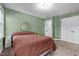 Green bedroom with large bed and a round mirror on the wall at 1 Gatesway Ct, Durham, NC 27707